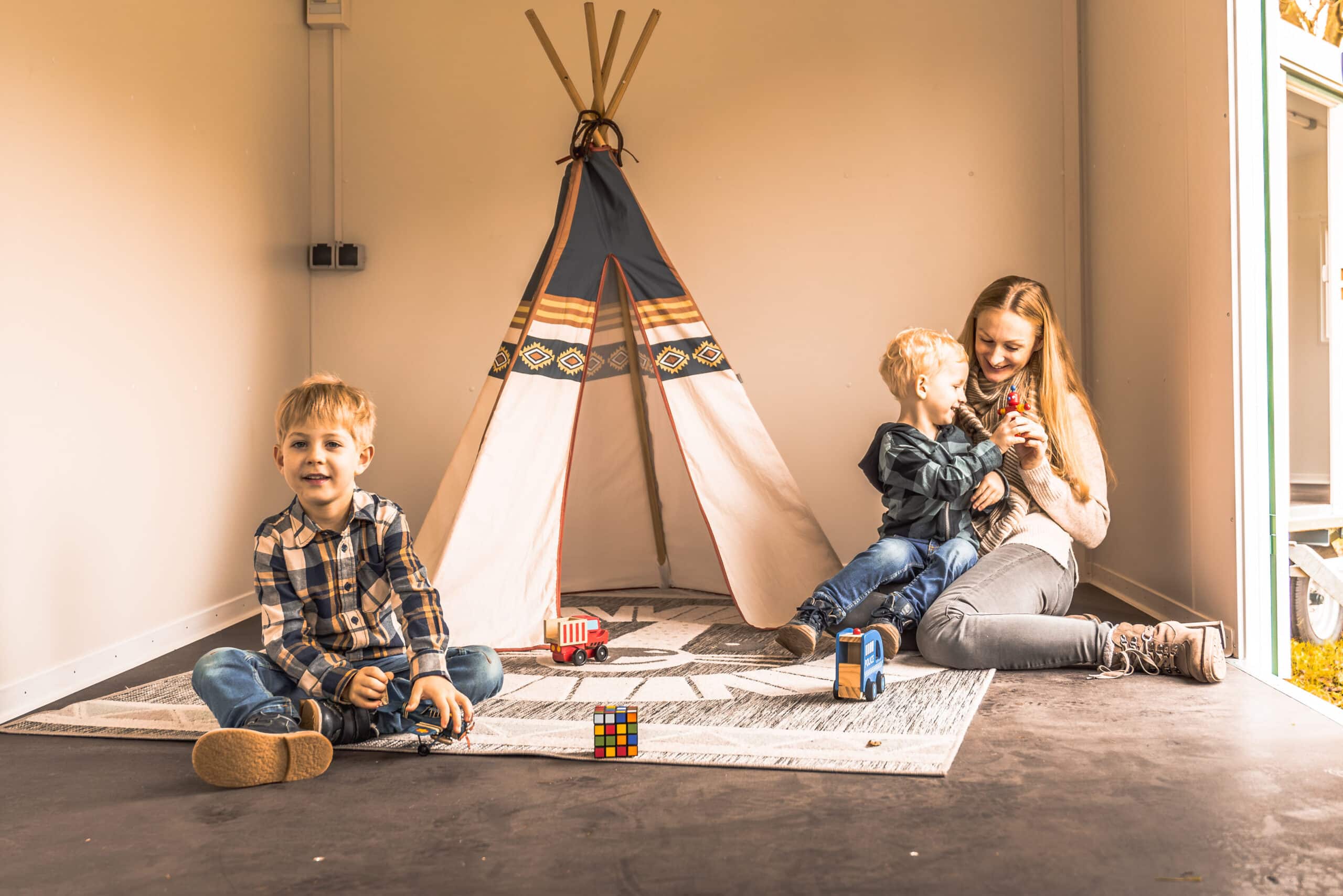 Kinder spielen in der Spielecke mit Tipi Zelt im Bauwagen.