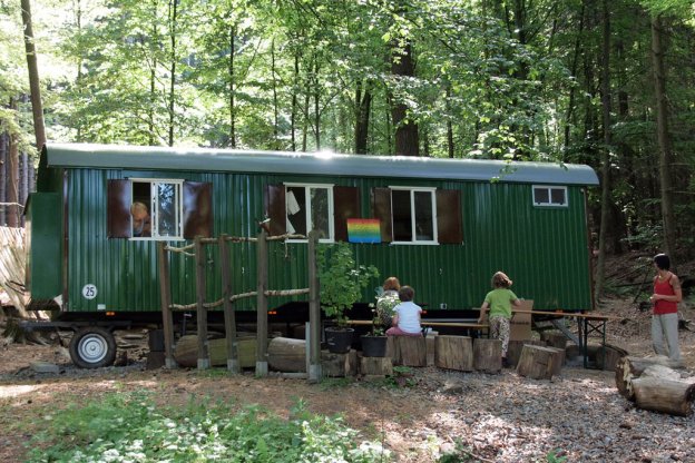 Großer Bauwagen im Wald als Waldkindergarten.