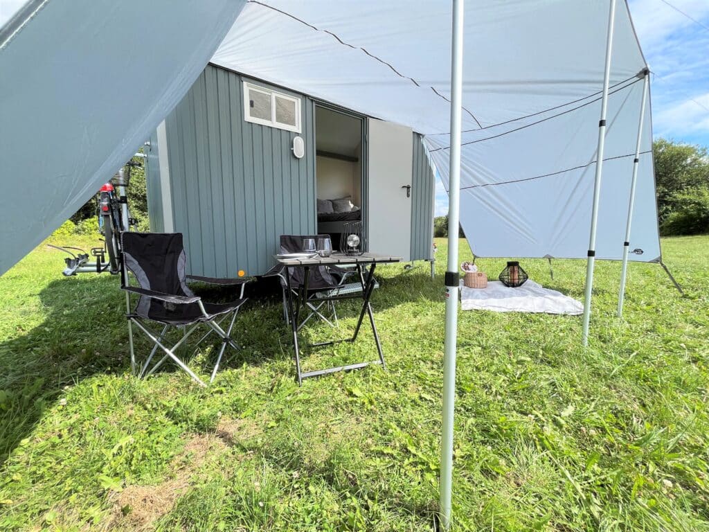 HBU Rolling Home mit Vorzelt und Campingstühlen.