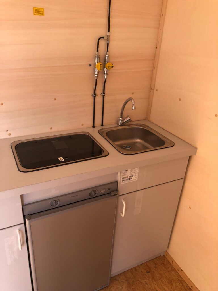 Küchenzeile mit Herd, Kühlschrank und Spüle